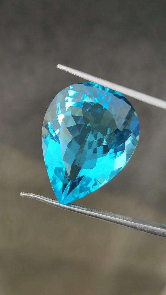 Капля грушевидной формы, стекло цвета небесно-голубого топаза, 21,95 карата, размер 24x18x10 мм.